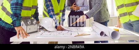 Banner background with construction team looking at blueprint plans on office table Stock Photo