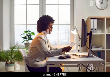 African american business woman working with documents at office at her workplace. Stock Photo