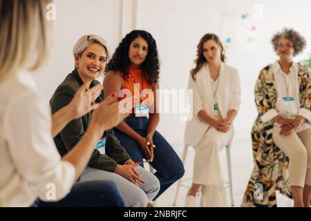 Happy businesswomen having a discussion during a conference meeting in a modern workplace. Group of multicultural businesswomen working together in an Stock Photo