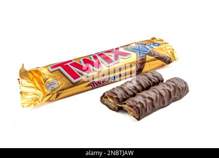 London. UK-02.12.2023. A packet of Twix chocolate bar with the chocolate in halves outside the packet isolated in white. Stock Photo