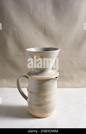 Handmade coffee dripper ceramic on  textile background. Stock Photo