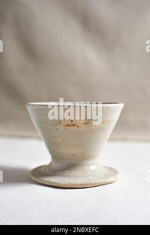 Handmade coffee dripper ceramic on  textile background. Stock Photo