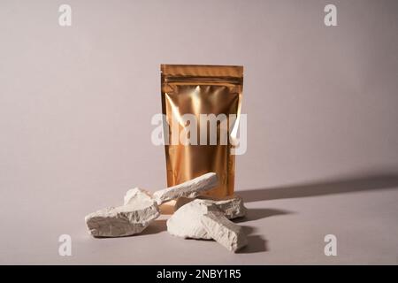 Bags made of gold kraft paper , front view with a shadow highlighted on a white light background. Layout of the packaging template for food and goods. Packaging with a clasp for tea leaves, coffee . Abstract minimalistic scene with geometric shapes. Stock Photo