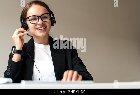 Woman agent of customer support center serving customer online, Call center worker in headset talking with client online. Stock Photo