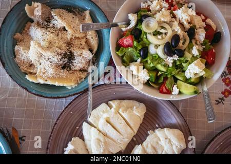 Greek Village Salad, umplings sprinkled with cheese and Halloumi cheese in restaurant in Cyprus island country Stock Photo