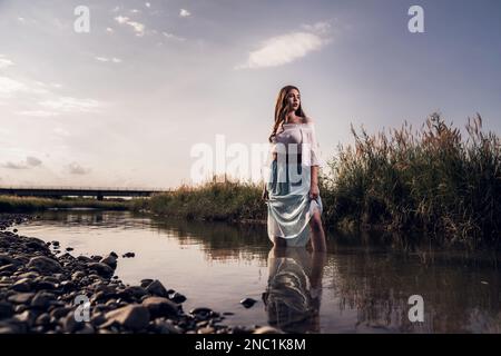 A young female standing in  river Stock Photo