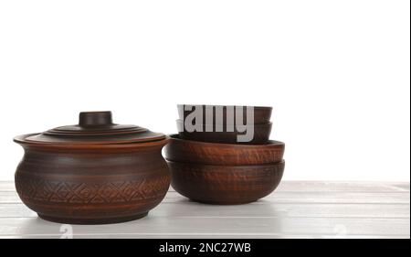 Different clay dishware on white wooden table Stock Photo