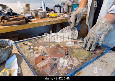 A girl is working with the paint in the studio. Stock Photo