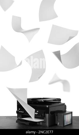 Modern multifunction printer on table and flying sheets of paper against white background Stock Photo