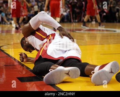 The Miami Heat's Dwyane Wade, left, holds a jersey with the number 11 that  honors his former agent Henry Thomas, who died in 2018, while teammate  Udonis Haslem, right, holds Wade's jersey