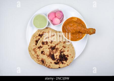 Butter chicken with tandoori roti served with chutney onion on white background Stock Photo