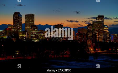 DENVER, COLORADO - FEBRUARY 2023: The beautiful Denver skyline against the warm cast of a winter sunset over the Rocky Mountains. Stock Photo