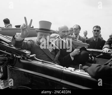 Winston Churchill, Britain’s wartime prime minister, gives his famous “V” sign greeting to inhabitants of the French city of Metz on July 14, 1946, as he rides through the streets, en route to a civic banquet held in his honor during Bastille Day celebrations. With him is Robert Schuman, French finance minister. (AP Photo/B.I. Sanders)