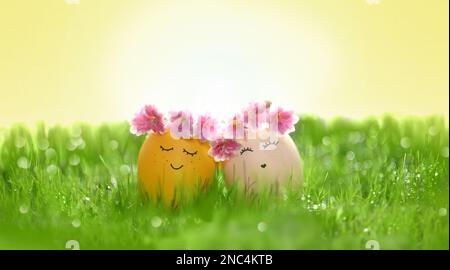 Row of two Easter eggs in fresh green grass. Holiday concept. Stock Photo