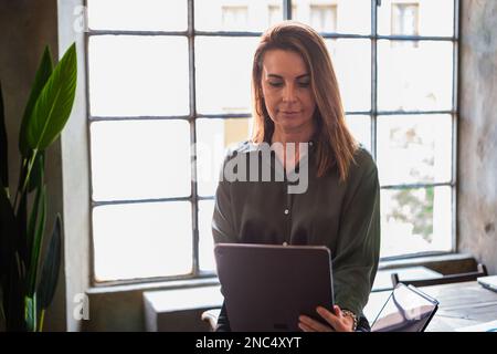 Business woman entrepreneur in office checking office data on tablet. Concept: Investment, female empowerment, business Stock Photo