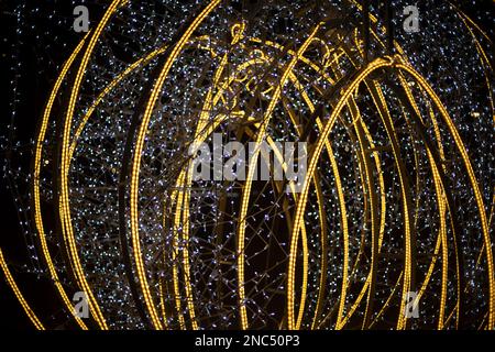 Design with lamps. Bright construction in city. Garlands on capital frame. Stock Photo