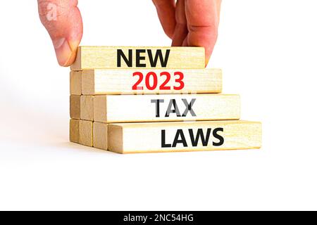 New 2023 tax laws symbol. Concept words New 2023 tax laws on wooden blocks. Beautiful white table white background. Businessman hand. Business new 202 Stock Photo