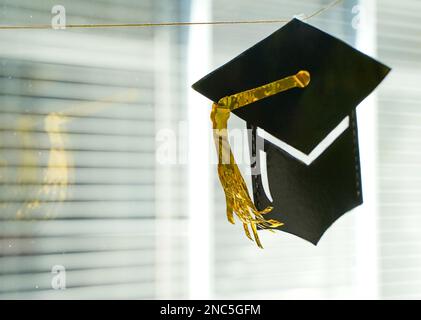 A closeup view of a black graduation cap with yellow brim Stock Photo