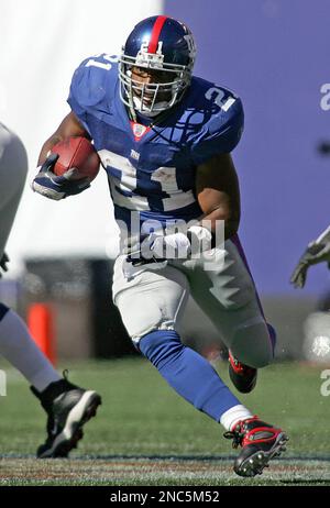 New York Giants Tiki Barber grabs his helmet as he walks off of