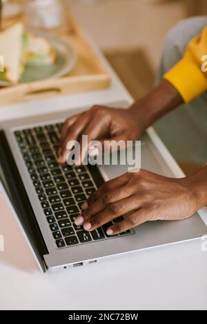 Closeup image of young woman typing on laptop when working at desk in home office Stock Photo