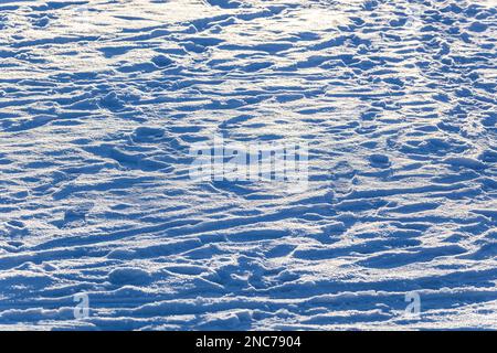 Tracks on the white snow in the sunlight. Texture. Background. Horizontal. Photo in high quality. Stock Photo