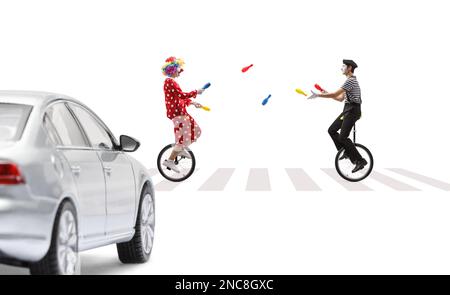 Street artist juggling and riding a mono cycle on a pedestrian crossing ...