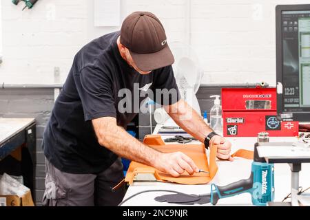 trimmer craftsman working with leather trimming inside the Morgan motor car factory in malvern worcestershire UK Stock Photo
