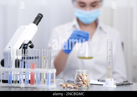 Pistachios on table and scientist proceeding quality control in laboratory Stock Photo