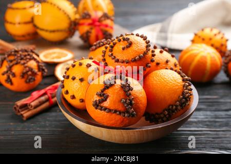 Pomander balls made of fresh tangerines and cloves on wooden table Stock Photo