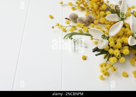 Beautiful floral composition with mimosa flowers on white wooden background, closeup. Space for text Stock Photo