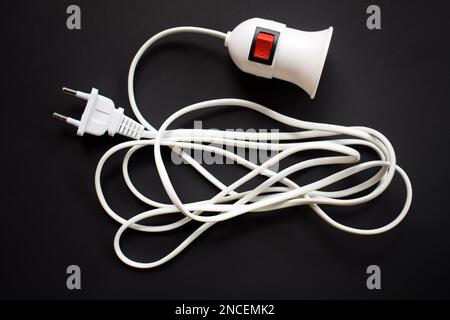 Light bulb socket with long wire isolated on black background. with on off button Stock Photo