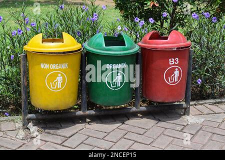 Different colored trash cans in the park. B3 (Hazardous waste), non organic and organic waste suitable for recycling. Segregate waste, sorting garbage Stock Photo