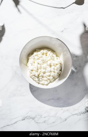 granulated cottage cheese in a white plate. High quality photo Stock Photo