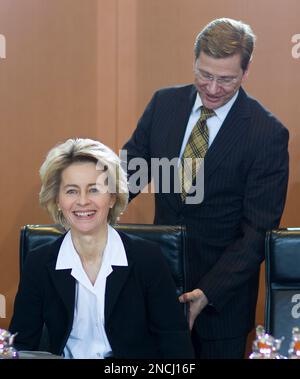 German Foreign Minister Guido Westerwelle, right, adjusts the chair of German Labour Minister Ursula von der Leyen, left, before the weekly cabinet meeting in the Chancellery in Berlin, Germany, Wednesday, Dec. 8, 2010. (AP Photo/Gero Breloer)