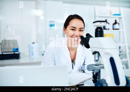 Ive observed something completely new. Portrait of a young scientist using a microscope in a lab. Stock Photo