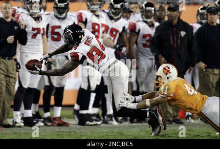 Atlanta Falcons wide receiver Roddy White (84) pulls defender Oakland  Raiders cornerback Michael Huff (24) during