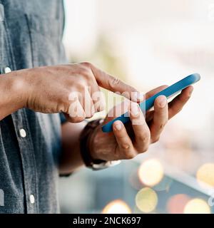 An indispensable device in modern times. a businessman using a smartphone against a city background. Stock Photo