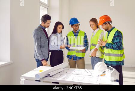 Team of diverse architects and engineers discussing construction plan during office meeting Stock Photo