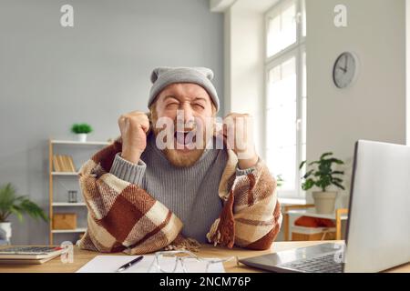Senior man gets angry and cries when he has to pay for expensive heating in cold winter Stock Photo