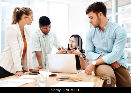 Combining each of their ideas into something cohesive. a group of businesspeople having a discussion in an office. Stock Photo