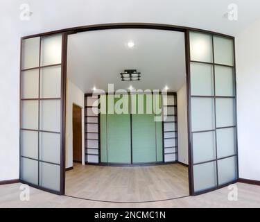 Wide angle photo of the repair of interior of new living room with sliding doors coupe in Japanese style Shoji with a wardrobe. Modern Asian design Stock Photo