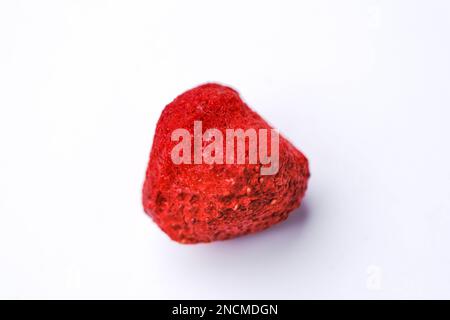 Freeze-dried strawberry, is a processed fruit that retains the nutritional value of food. A piece of freeze-dried strawberry isolated on white backgro Stock Photo