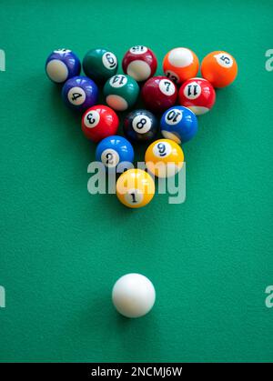 Rack a table for pool with spots and stripes balls, selective focus. Mini billiard, vertical format Stock Photo