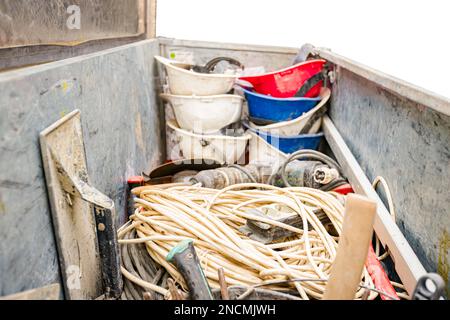 Steel crate, container, toolbox overfull of many different tools were placed in the truck trailer on the construction site. Stock Photo