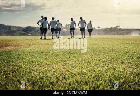 The rain doesnt stop these champions. Full length shot of a group of handsome young rugby players training together on a rainy day on the field. Stock Photo