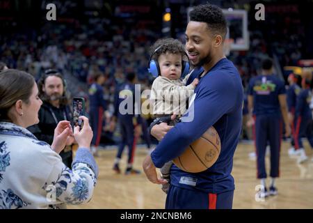 New Orleans Pelicans guard CJ McCollum, right, holds his son