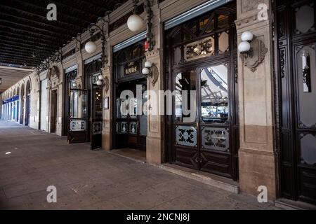 Pamplona, Spain - August, 01, 2022: Arched colonnade by the historic Iruna cafe, frequented by Ernest Hemingway on Plaza del Castillo square in Old To Stock Photo