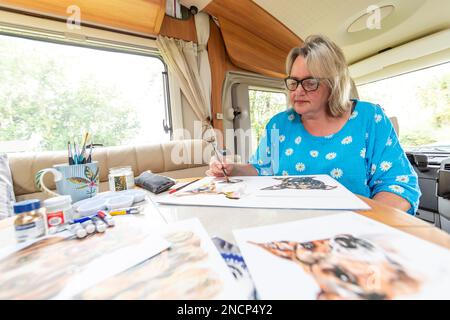 Renowned commercial artist Jo Scott abandons her studio to improve work life balance. Working anywhere in her state of the art, connected motorhome Stock Photo