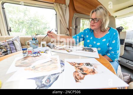 Renowned commercial artist Jo Scott abandons her studio to improve work life balance. Working anywhere in her state of the art, connected motorhome Stock Photo