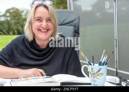 Renowned commercial artist Jo Scott abandons her studio to improve work life balance. Working anywhere in her state of the art, connected motorhome Stock Photo